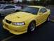 2002 Ford Mustang - Yellow 2002 Ford Mustang coupe with aftermarket body kit and chrome wheels.