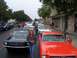 2002 Ford Mustang - Several classic Ford Mustangs are lined up on a street, possibly for a parade or car show.