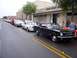 2002 Ford Mustang - A line of classic Ford Mustangs parked on a street, with a black convertible in the foreground.