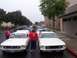 2002 Ford Mustang - Two white 1967 Ford Mustangs are lined up, possibly for a parade, with American flags visible.