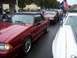 2002 Ford Mustang - Several Ford Mustang convertibles are lined up, decorated with American flags and Mustang emblems.