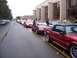 2002 Ford Mustang - A line of cars, including several red Mustangs, participate in a parade.