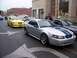2002 Ford Mustang - Several Ford Mustangs are lined up on a street, with a man standing near one of them.