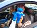 2002 Ford Mustang - A man holds a blue teddy bear with a Ford logo inside a 2002 Ford Mustang during a parade.
