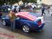 2002 Ford Mustang - A blue 2005 Ford Mustang GT is decorated with an American flag during a parade.
