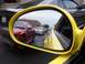2002 Ford Mustang - Traffic jam includes a red Mustang and a silver Mustang, seen from a yellow car's side mirror.