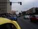 2002 Ford Mustang - Multiple Ford Mustangs drive down a street during a parade, with spectators on the side.