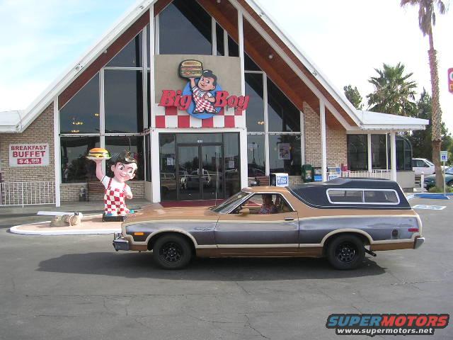 Brown and grey Ford Ranchero with a black camper shell, parked in front of a Big Boy restaurant