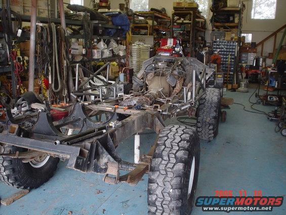 Off-road vehicle chassis with large tires in a workshop