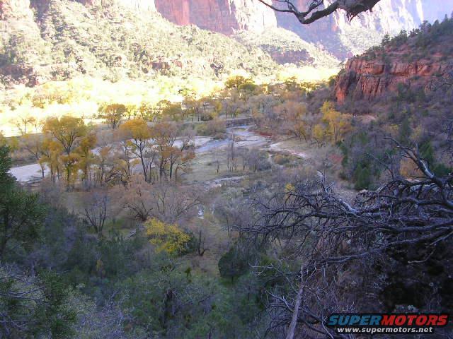 Mountain valley with a river and trees in autumn colors, seen from above