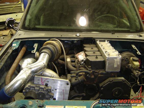 Engine bay with a large turbocharger, custom intake manifold, and a Cummins diesel engine installed. The vehicle appears to be a Ford Ranger
