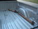 1994 Jeep YJ - A rusty driveshaft rests in the ribbed bed of a silver pickup truck.