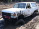 1989 Ford Bronco - A white Ford Bronco is heavily caked in mud while stuck in a muddy terrain.