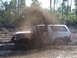 1989 Ford Bronco - A white 1989 Ford Bronco kicks up a large spray of mud while navigating a muddy trail.