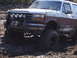 1989 Ford Bronco - Muddy 1989 Ford Bronco navigating difficult terrain off-road.