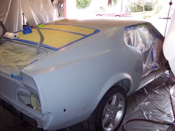 car body with masking tape on the roof and plastic sheeting covering windows