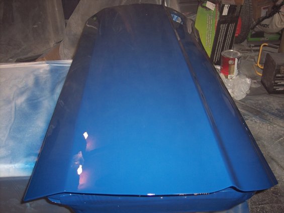 blue car hood, possibly a Ford Mustang, in a garage setting
