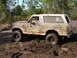 1989 Ford Bronco - Mud-covered 1989 Ford Bronco stuck in a muddy off-road environment.