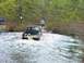 1988 Jeep Comanche - A Jeep pickup truck navigates through a watery terrain, kicking up spray.