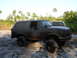 1989 Ford Bronco - Muddy 1989 Ford Bronco after off-roading, with another vehicle visible in the background.
