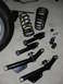 1990 Ford Mustang - Various black suspension components, including control arms and coil springs, are laid out on a concrete surface.