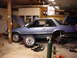 1990 Ford Mustang - 1990 Ford Mustang coupe in a garage with suspension parts laid out for service.