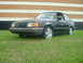 1989 Ford Escort - This 1989 Ford Escort coupe is parked on a grassy area in front of a building.