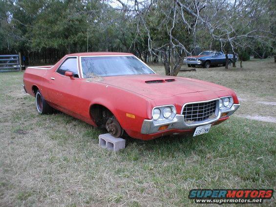 Red 1972 Ford Ranchero with missing front wheel, on cinder blocks
