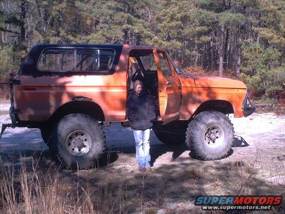 Orange Ford Bronco with a person standing in the open driver's door