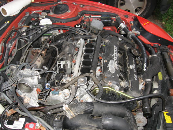 Mitsubishi V6 engine bay with hoses and wiring visible
