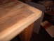 1988 Ford Bronco - The image shows a close-up of a wooden table's edge, with a table leg visible, and background items including a box and striped paper.