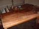 1988 Ford Bronco - A dining table is in the process of being refinished in a garage setting, with various supplies visible.