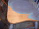 1988 Ford Bronco - A chair seat is partially painted blue and gray, with some of the original wood grain visible.
