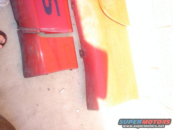 red and yellow car body panels laid out on the ground