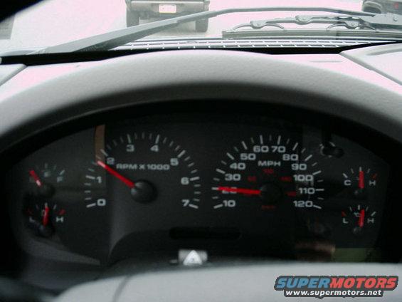 Dashboard gauges with red needle on tachometer at 2000 RPM and speedometer at 30 MPH. Water and fuel gauges visible