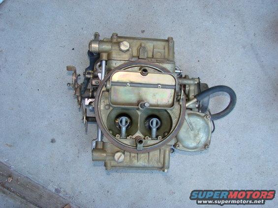 Holley carburetor with two barrels, sitting on a concrete floor