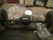1992 Ford Crown Victoria - A rear axle assembly with wheels is shown, covered in plastic, in what appears to be a workshop.