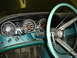 1992 Ford Crown Victoria - The interior of a vintage car shows a turquoise dashboard with two prominent gauges and a light blue steering wheel.