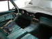 1992 Ford Crown Victoria - The interior of a vintage car features teal upholstery, a distinctive steering wheel, and a dashboard with analog gauges.