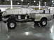 1999 Ford F-150 - A pickup truck's chassis and engine are visible, with the bed attached, next to a large dump truck.