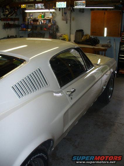 White 1967 Ford Mustang coupe, rear quarter panel visible, in a garage