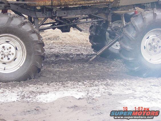 Big tires of a monster truck stuck in mud. The vehicle has a rusty frame