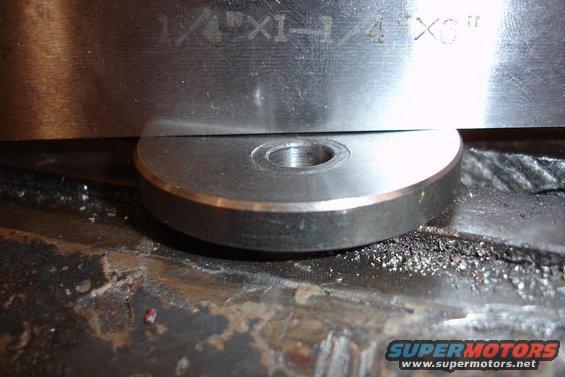 Metal part with engraved text '1/4"X1-1/4"X3"' resting on a rough surface