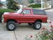 1979 Ford Bronco - This lifted red Ford Bronco, likely a 1978 model, is parked on a paved driveway with a black top.