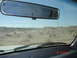 1996 Ford Bronco - Multiple SUVs travel in a dusty convoy across a desert landscape, viewed from inside a vehicle.