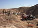 1996 Ford Bronco - Several off-road vehicles are gathered in a desert canyon with people observing.