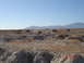 1996 Ford Bronco - Multiple off-road vehicles traverse a desert landscape, kicking up dust on a clear day.