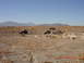 1996 Ford Bronco - Multiple off-road vehicles traverse a desert terrain under a clear blue sky.