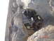1996 Ford Bronco - A 1996 Ford Bronco is precariously positioned on a steep, rocky incline, with dust rising around it.