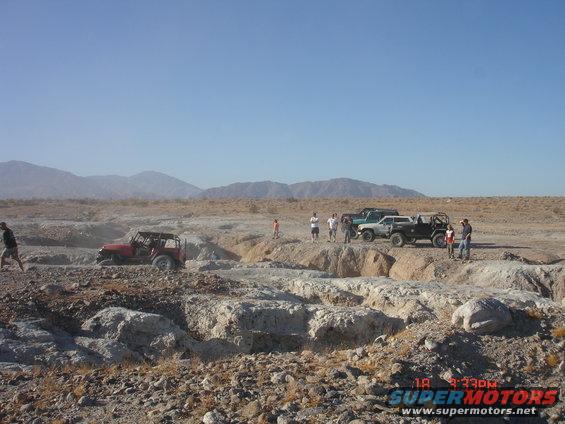 Off-road vehicles in a desert landscape with people